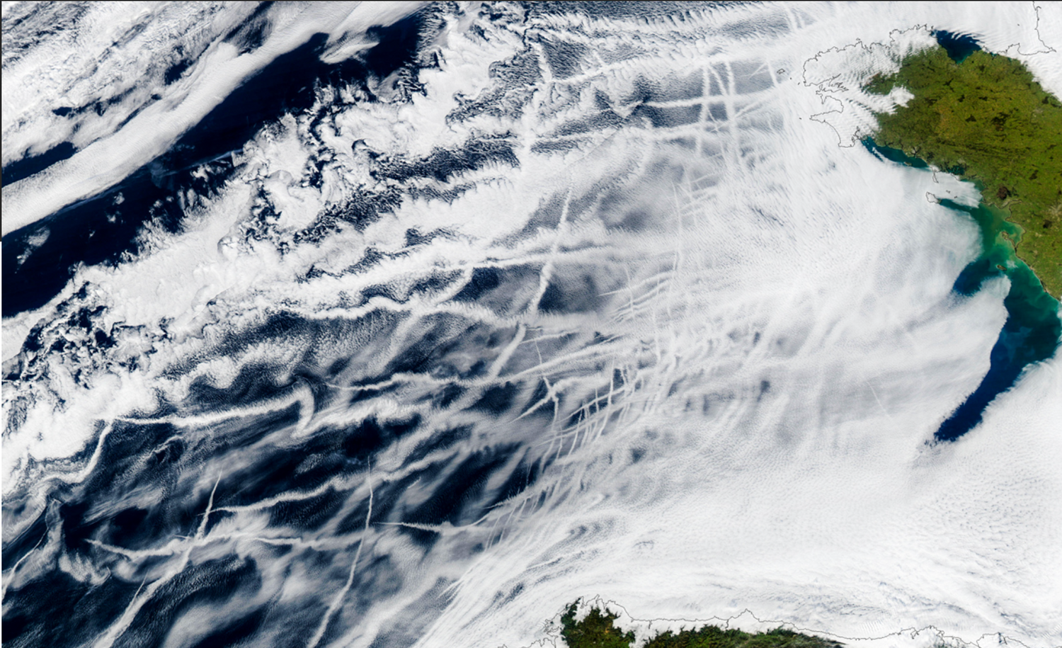 Crisscrossing clouds known as ship tracks can be seen off the coast of Spain in this 2003 satellite image. With the phasing out of high-sulfur ship fuel, these reflective clouds have become scarcer, leading to ocean warming.